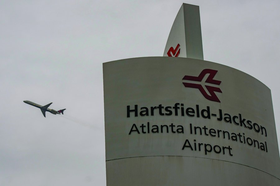 Atlanta airport sign with a plane flying in the background