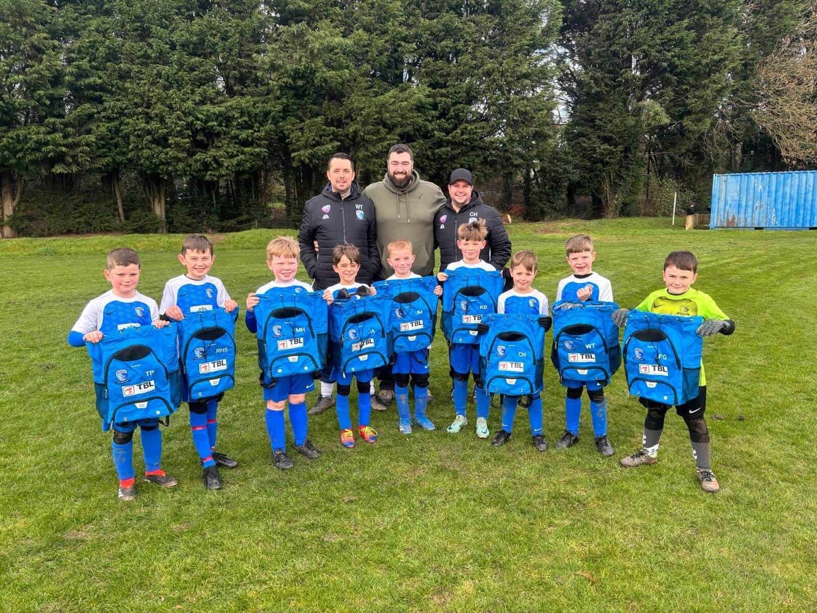 Copsewood young football team holding up bags with TBL logo