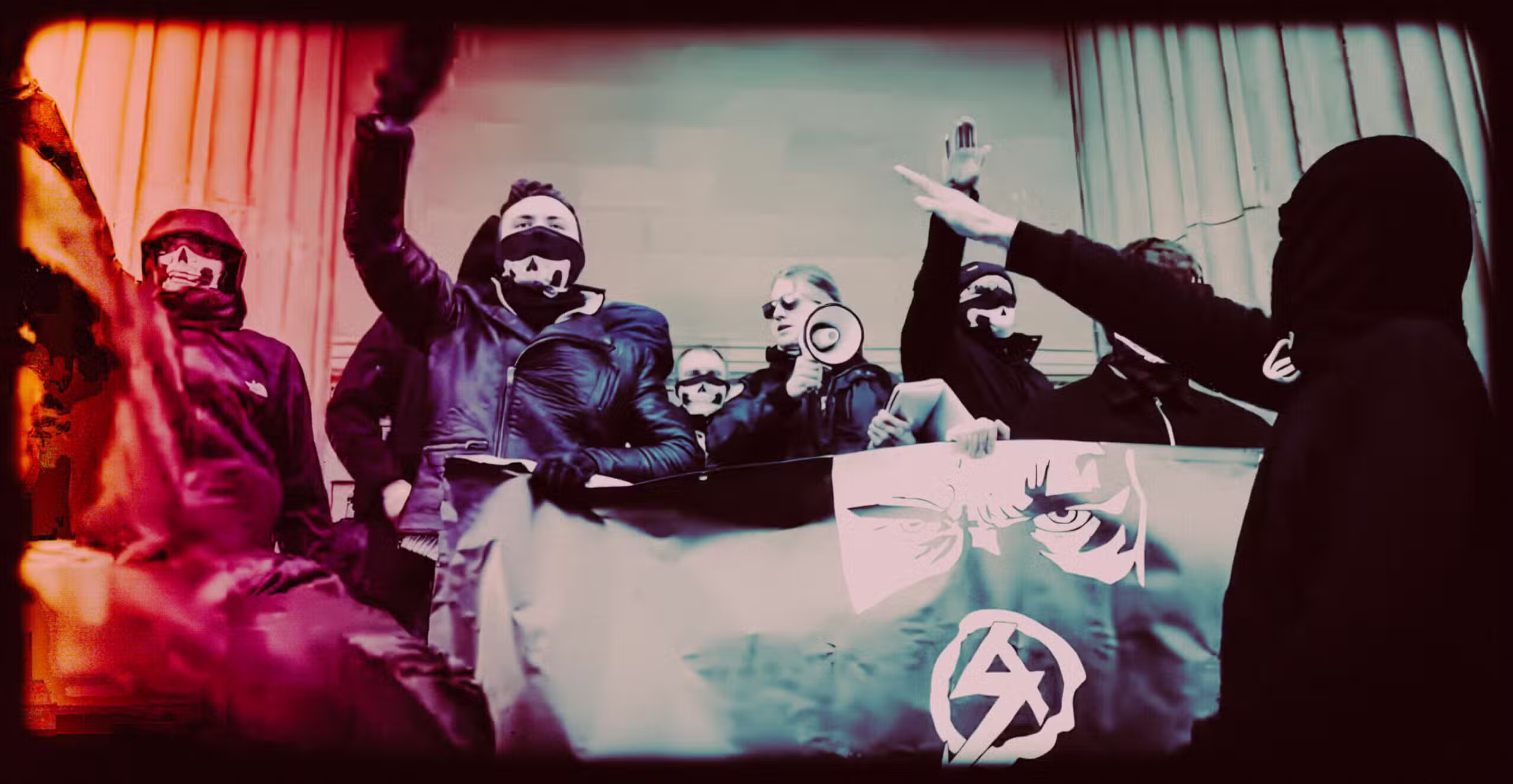 Masked protesters holding signs during an underground demonstration.