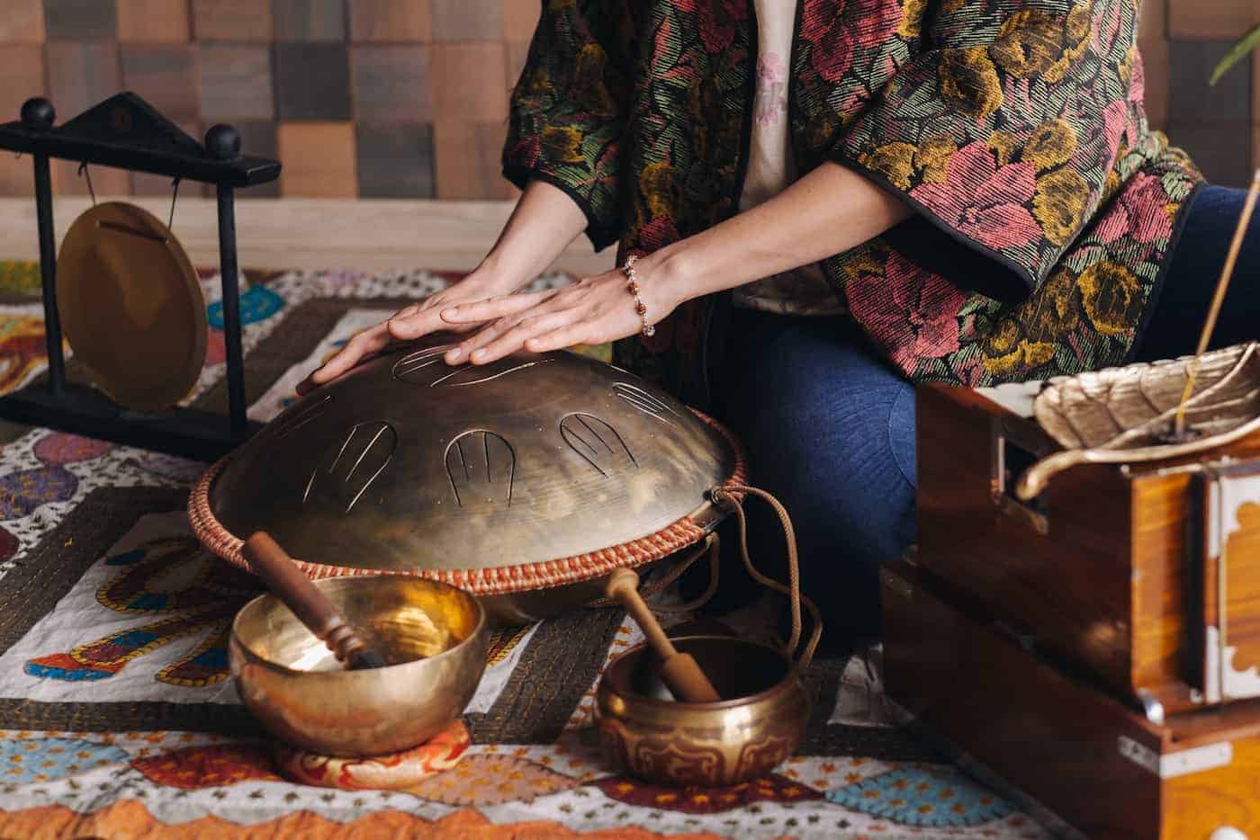 Woman playing tongue drum in sound bath