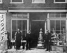 IMG_062thumb Old black and white photograph of The History Museum storefront with people standing outside.