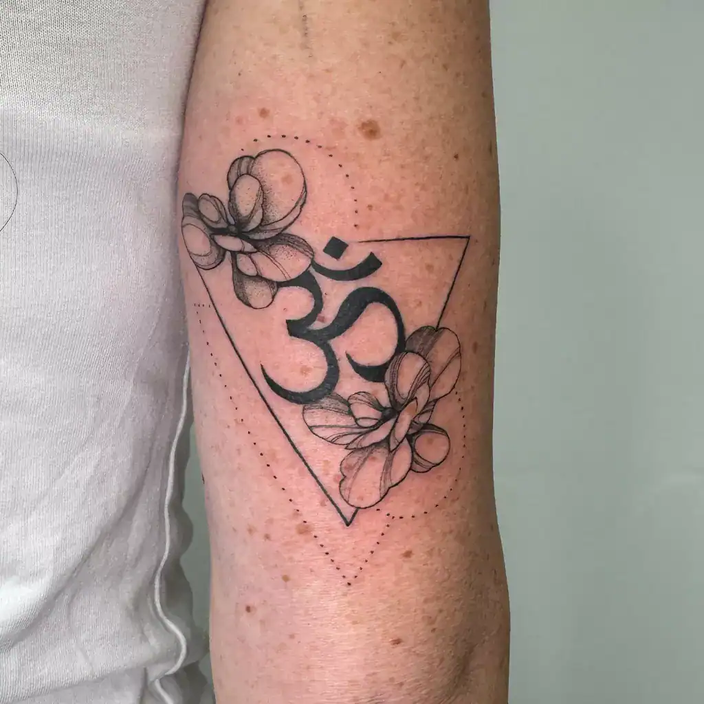 Fineline Tattoo mit kleinen Blüten und geometrischen Elementen