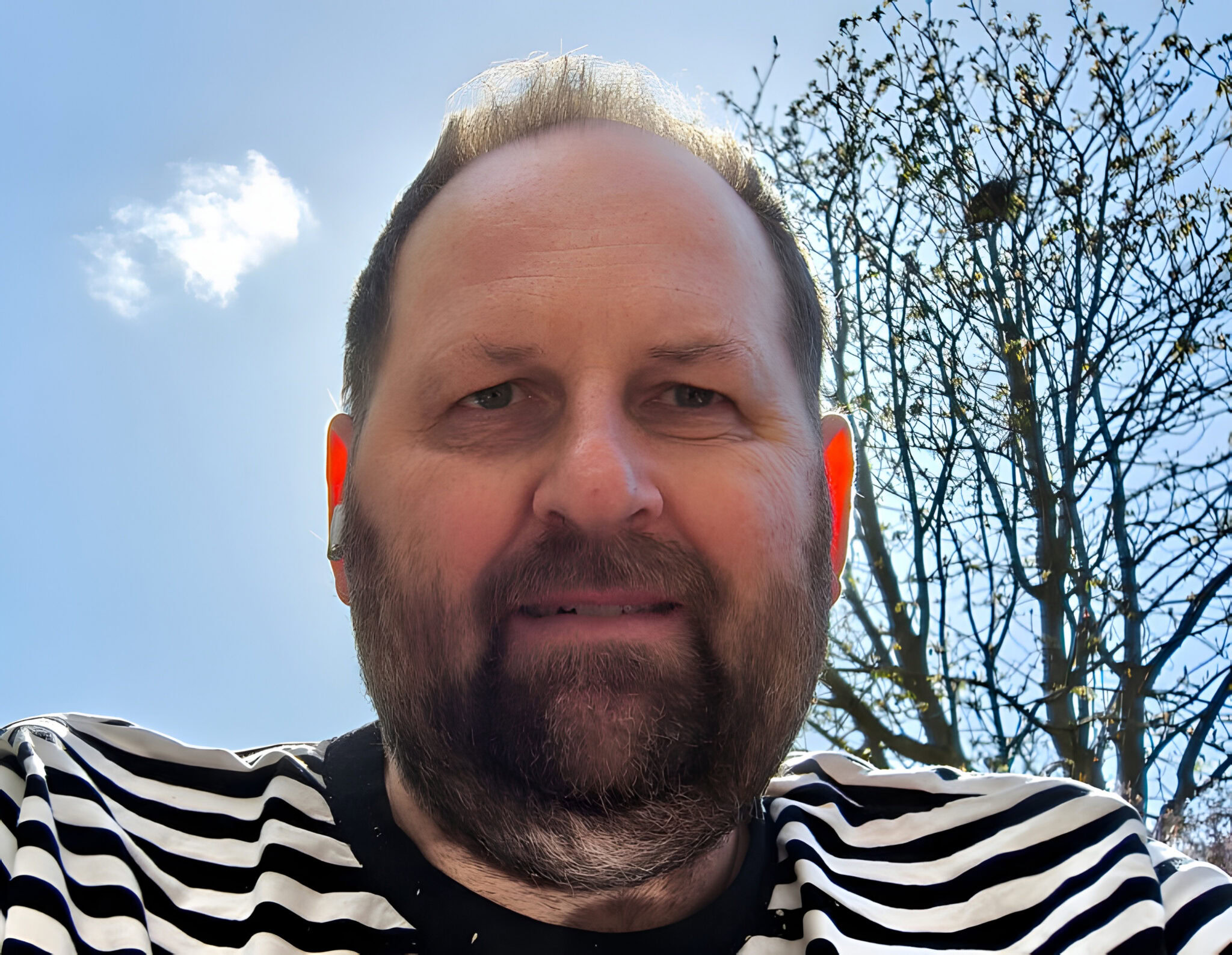 Mann mit gestreiftem Shirt im Freien