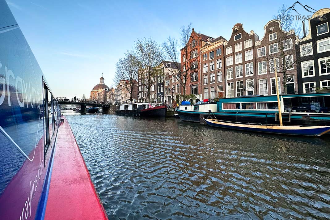 Der Blick von einem Boot auf die schiefen Häuser in Amsterdam