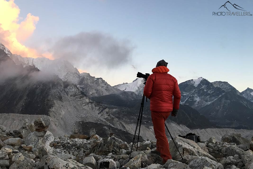 Fotograf Florian Westermann steht am Abend vor einer imposanten Bergkulisse in Nepal, vor ihm ein Stativ mit einer Kamera