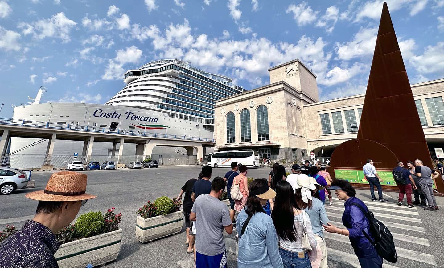 Seniors disembark from a docked cruise ship as long-term cruise living gains popularity.