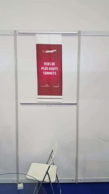 Fabric banner with metal bar with hooks on exhibition panels