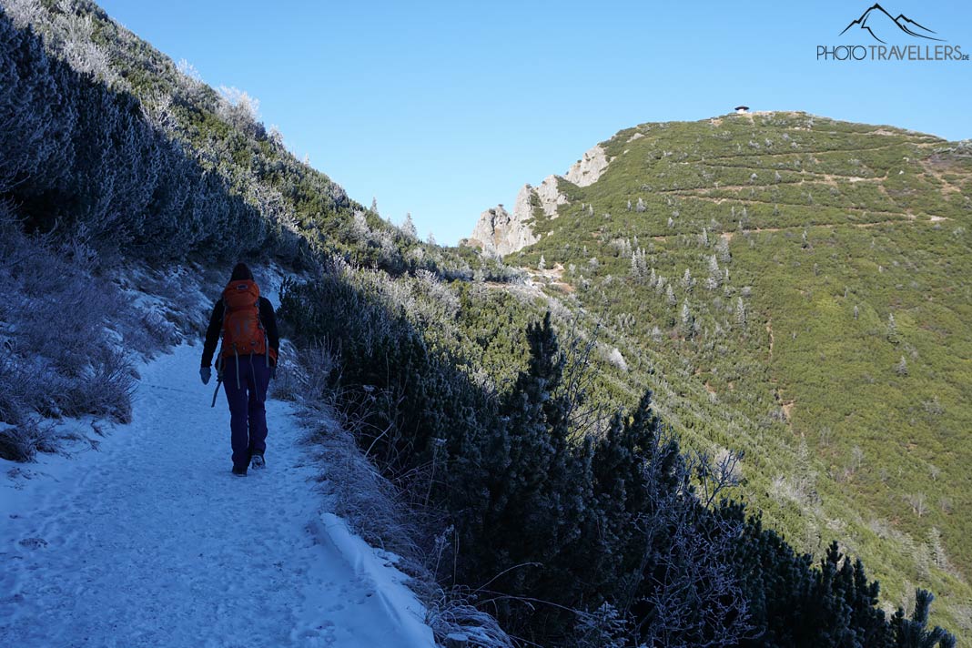 Reisebloggerin Biggi Bauer auf einem breiten Wanderweg, dahinter der Gipfel des Herzogstands