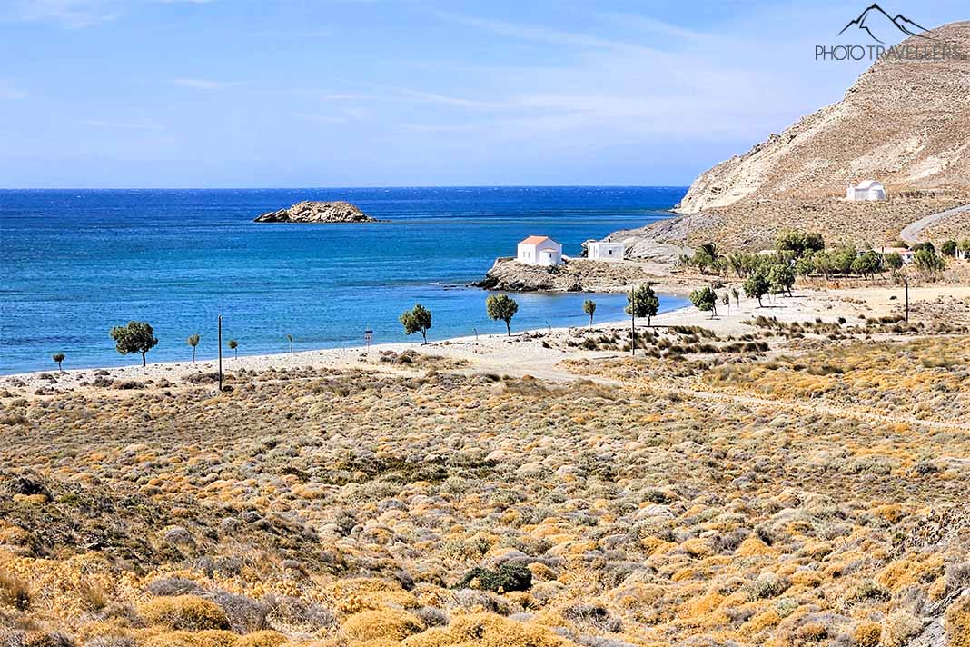 Kleine Kapelle vor Felsen am Meer mit Strand und Bäumen