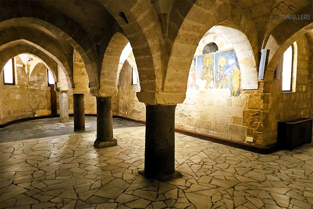 Säulenbögen aus Stein mit einem bunten Relief in der Kathedrale von Taranto