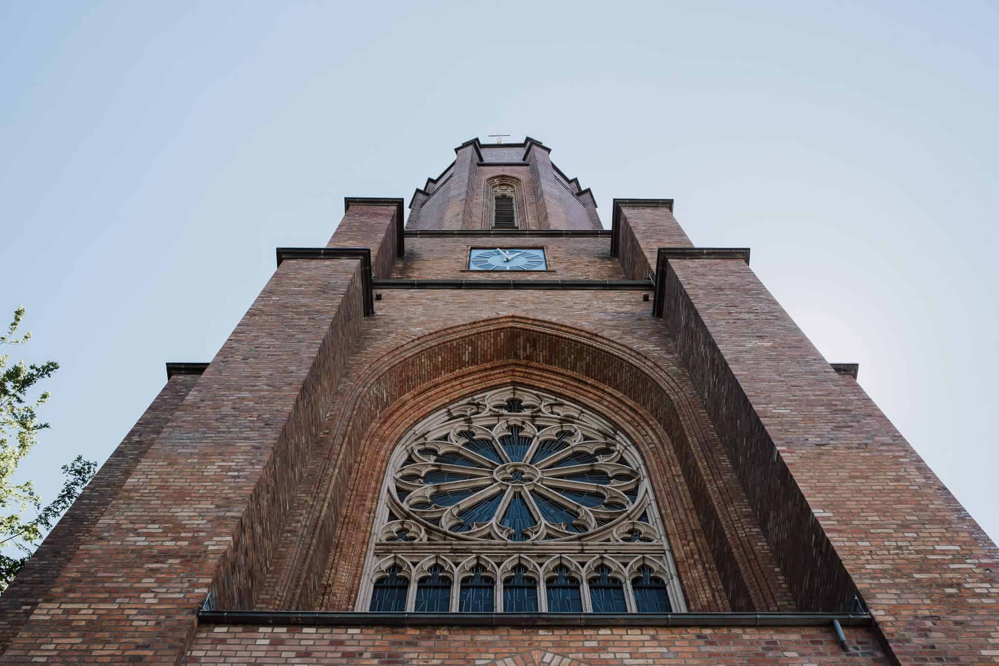 Backsteinkirchturm auf Gut Hohenholz, Rundbogenfenster und Uhr – Hochzeitsfotografin Köln.