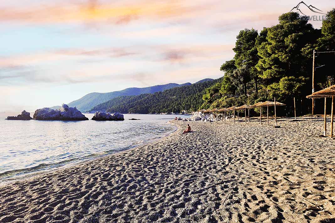 Abenddämmerung am Sandstrand von Milia mit Bäumen am Ufer