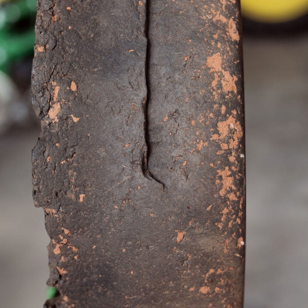 Close-up of an OEM tire showing visible signs of wear and deterioration, highlighting cracks and damage caused by long-term use.