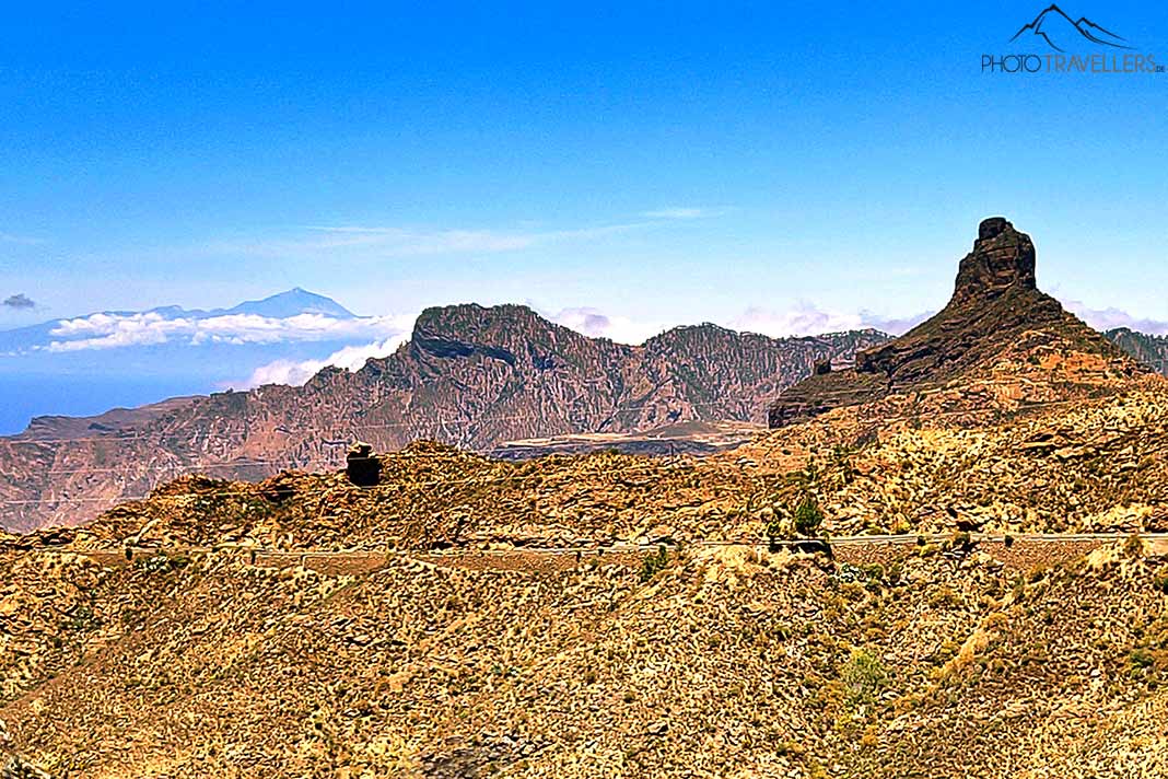 Gelbes und rotes Gestein dominieren die Felslandschaft von Grand Canaria mit dem Roque Nublo im Hintergrund