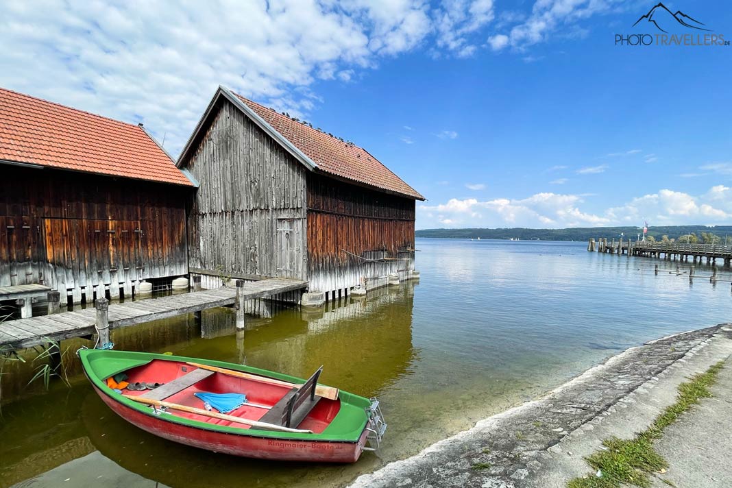 Ein buntes Ruderboot und ein Bootshaus in Dießen am Ammersee