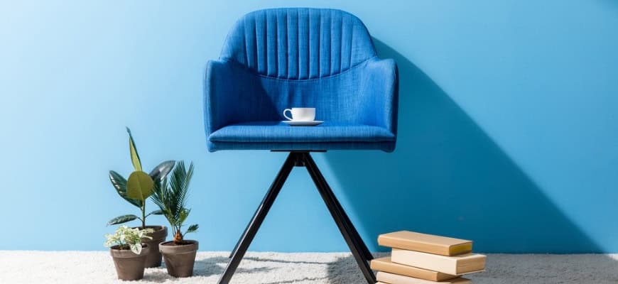 Blue chair, flower pots on the ground and wooden blocks with blue wall