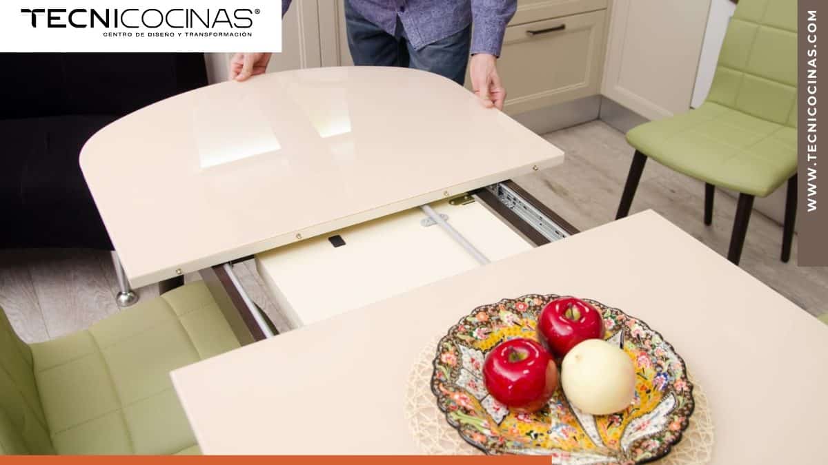 Mesa extensible blanca con sistema telescópico en cocina moderna mostrando mecanismo de apertura central