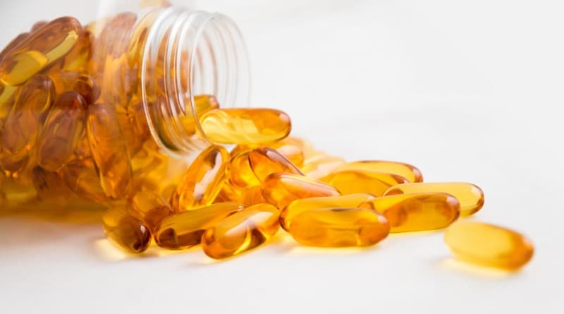 Golden Yellow Transulcent Capsules spilling out of Clear Jar - Preparing For Your Fitness Journey