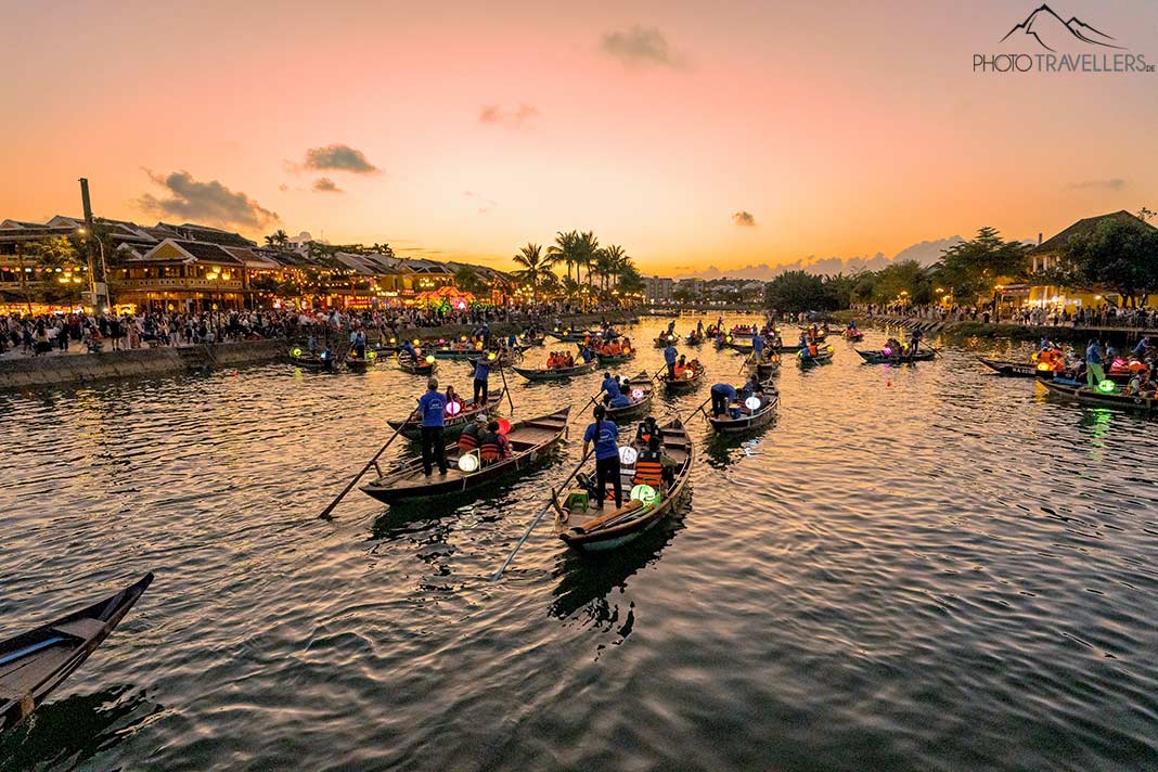 Ruderboote mit Touristen im Abendlicht auf dem Fluss in Hoi An
