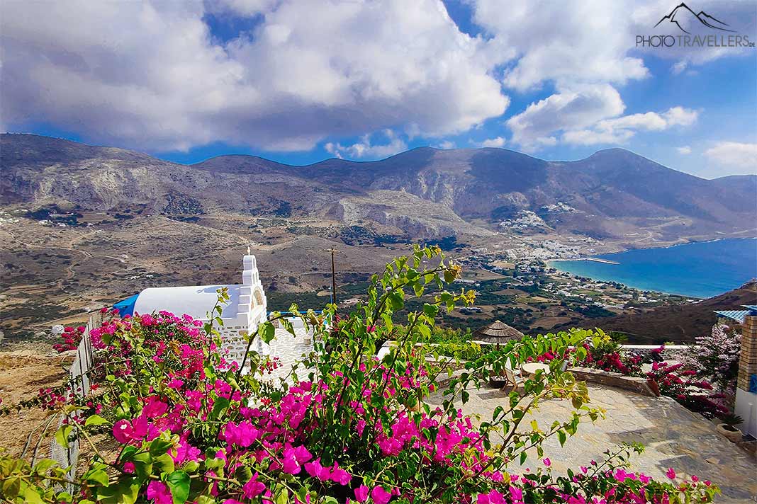 Über der Bucht von Aegiali thront eine weiße Kapelle und ein pinkfarbenes Blumenmeer