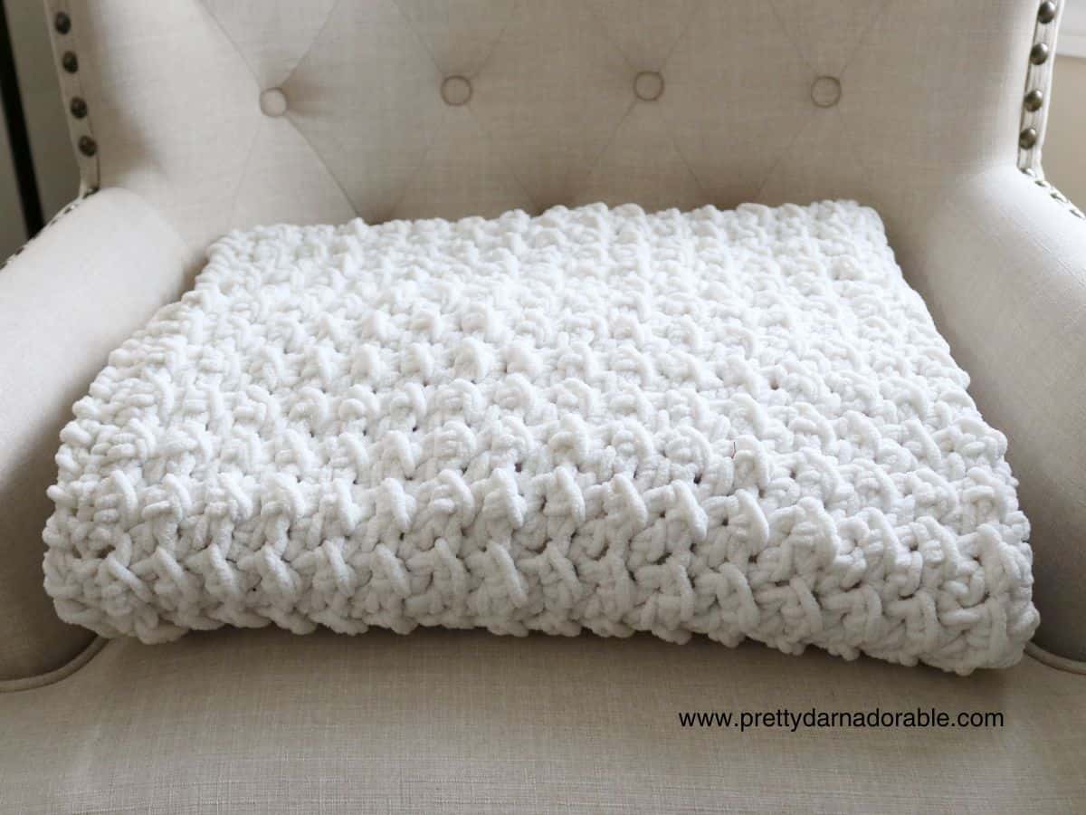 Creamy chunky throw blanket folded on a chair - Free crochet throw pattern