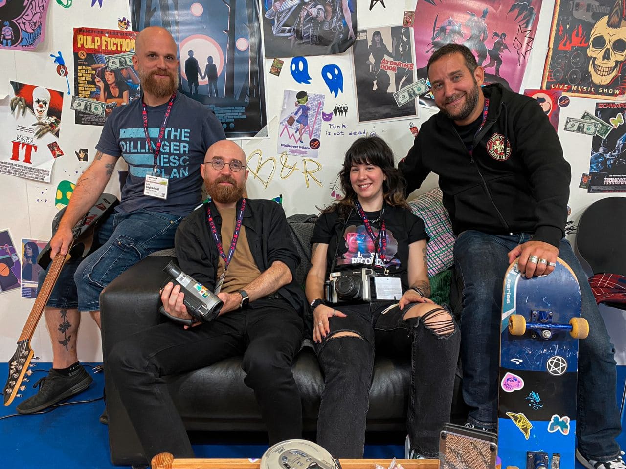 GAMESCOM 2024 Bloom & Rage "Groupe de personnes, fans de jeux vidéo et de culture pop, posant dans un décor coloré avec posters, accessoires de gaming, et skateboards, lors d'un événement Air-Gaming.".