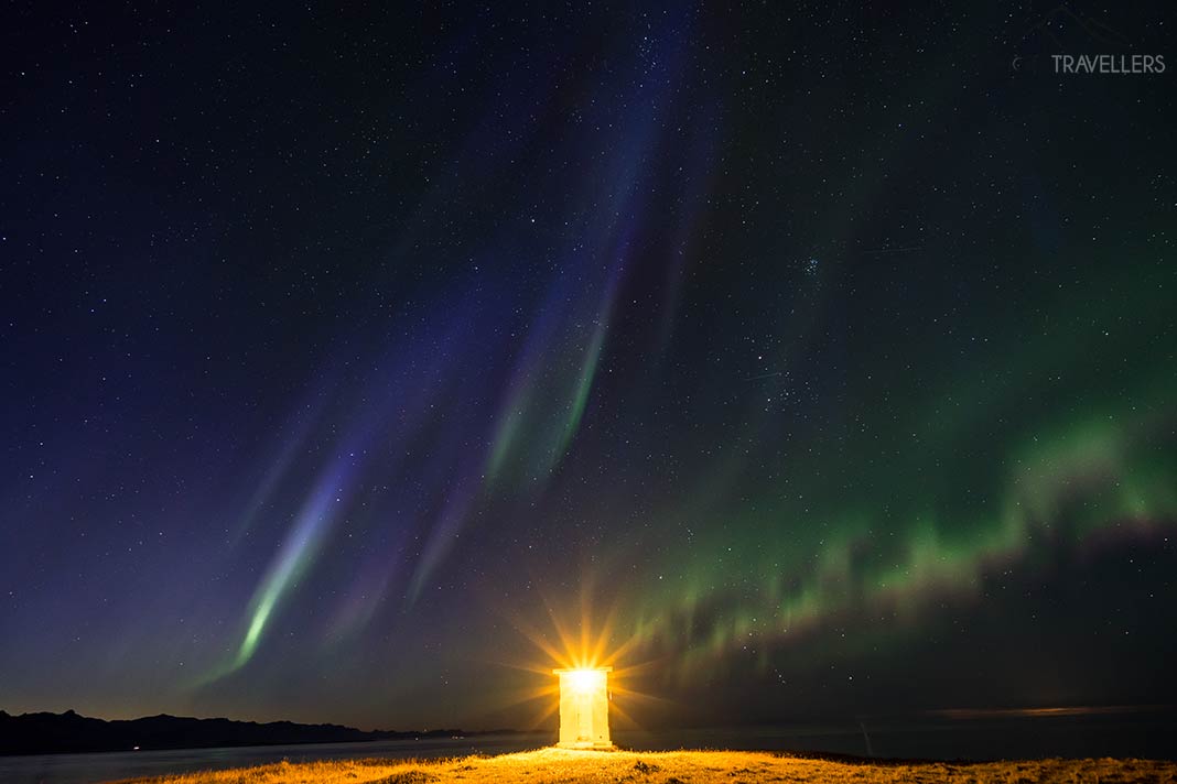 Ein Leuchtturm mit Polarlichtern auf Island