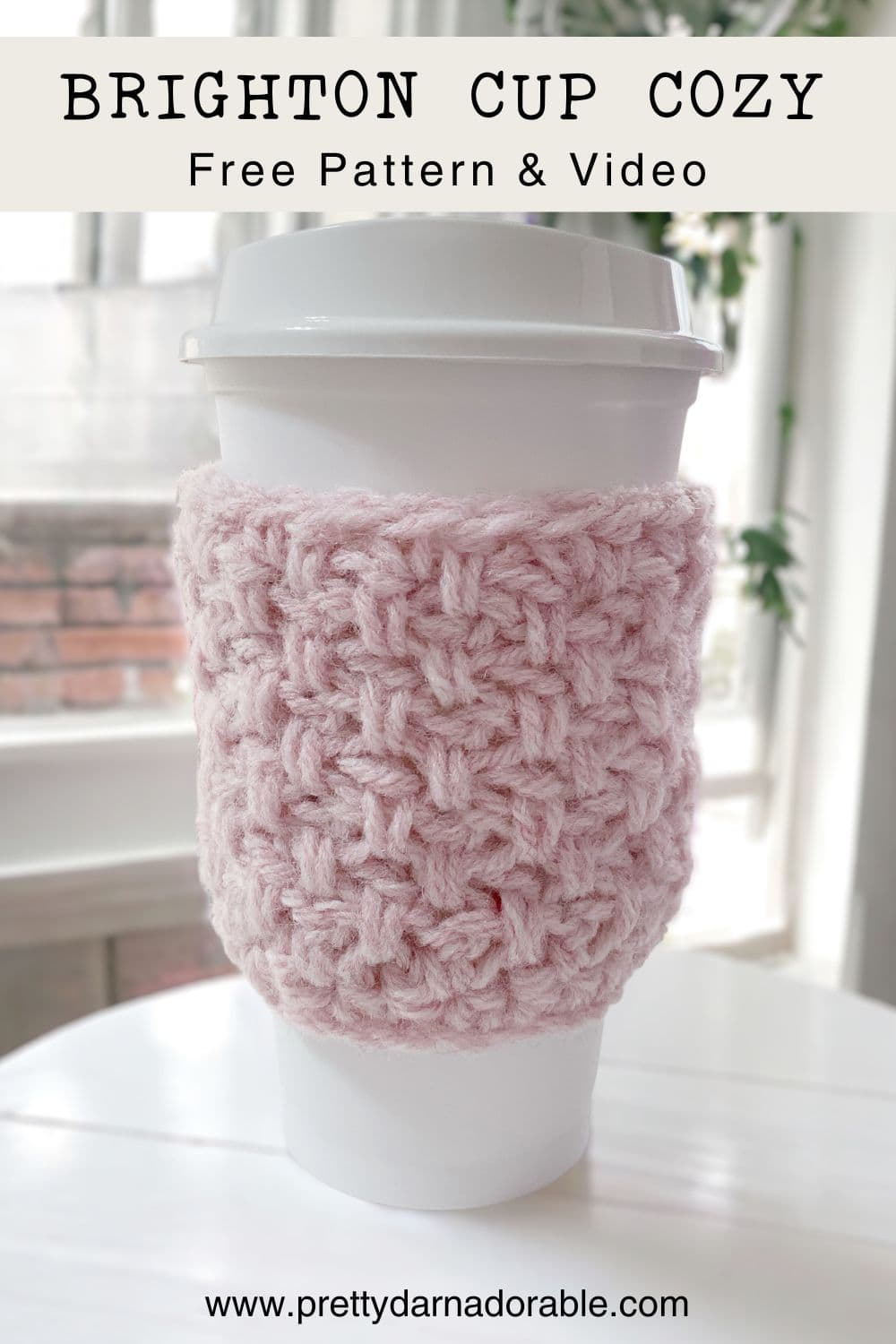 pink crochet cup cozy in front of a window