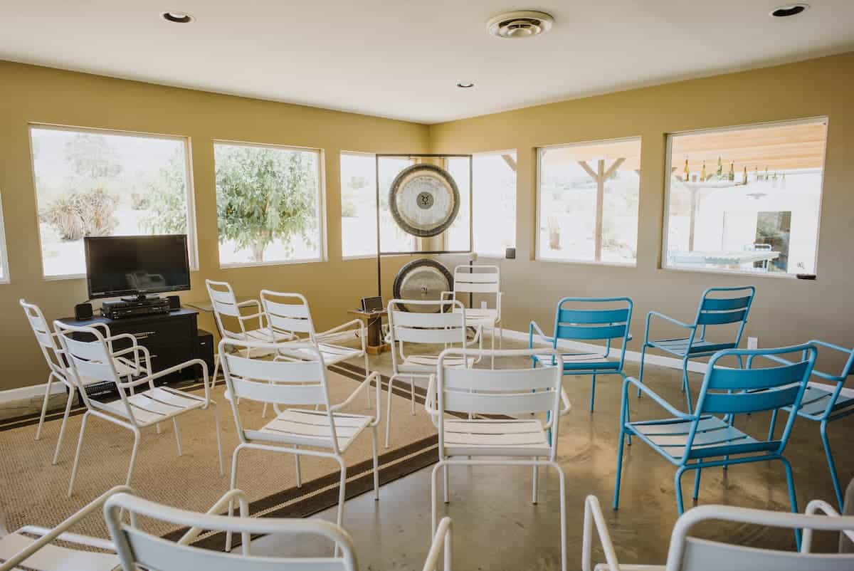 Two gongs set up in front of a room of empty chairs