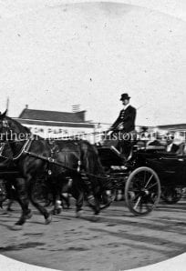 William Jennings Bryan 1896 Horse-drawn carriage with people in vintage clothing, historic urban street scene, early 20th century.
