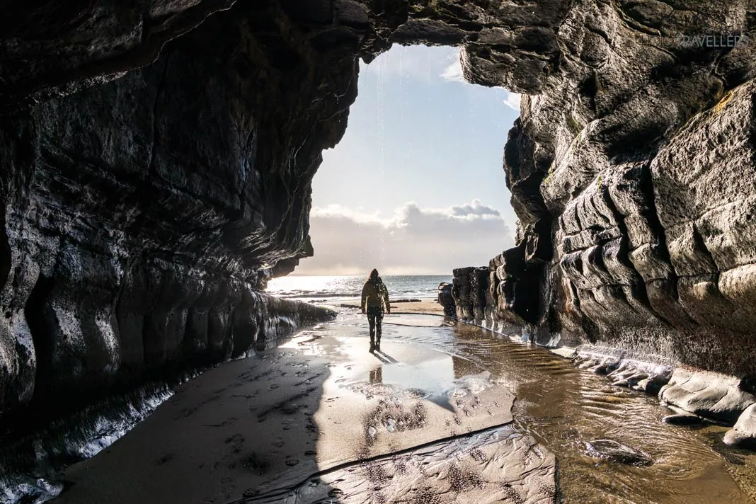 Ein bearbeitetes Foto einer Höhle, in der eine Frau im starken Gegenlicht steht