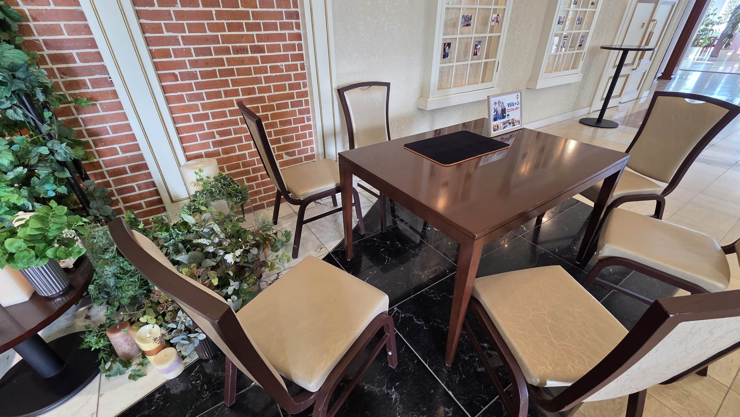 【2026年版】出張マジシャンの料金はいくら?シーン別・規模別の費用相場をプロが本音で解説 6 インペリアルウィング富山迎賓館の結婚式場に設営されたテーブルマジックのスペース。レンガ調の壁とグリーンに囲まれた上品な空間