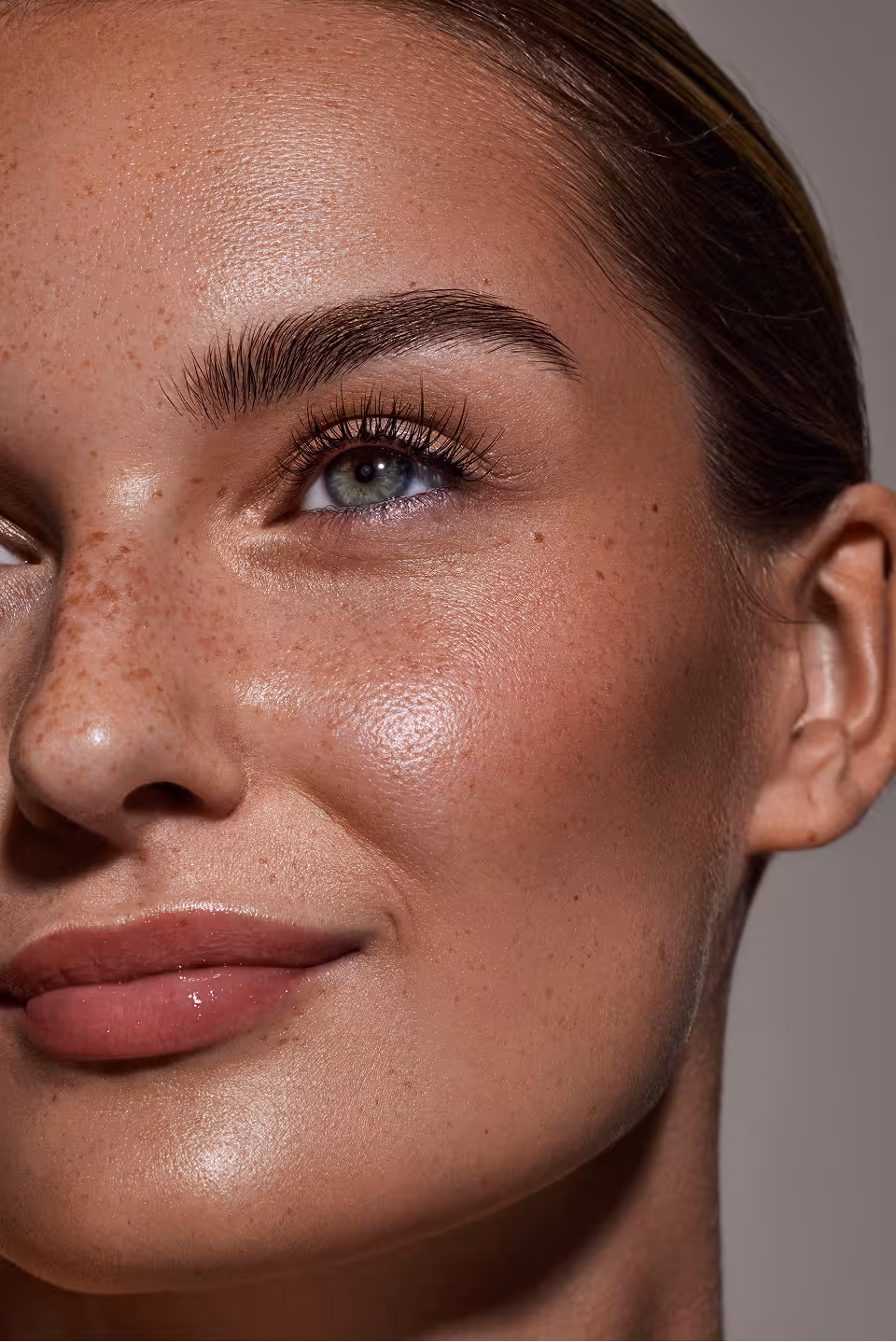 Porträt einer geschminkten Frau mit braunen Haaren, die nach rechts blickt, vor neutralem Hintergrund Make-up Artist Ausbildung Vollzeit