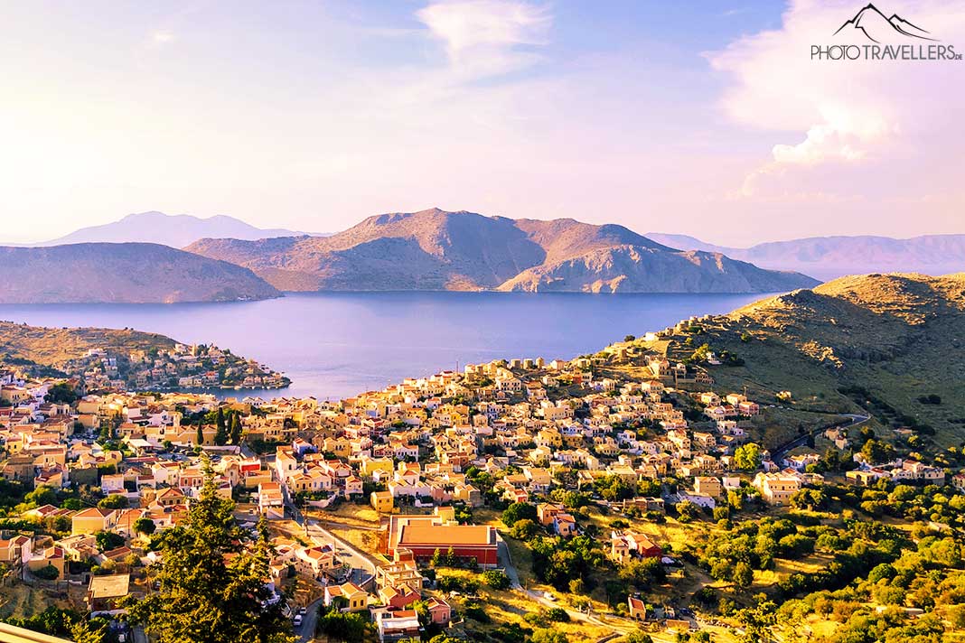 Die Altstadt von Symi von oben betrachtet mit den umliegenden Inseln im Hintergrund