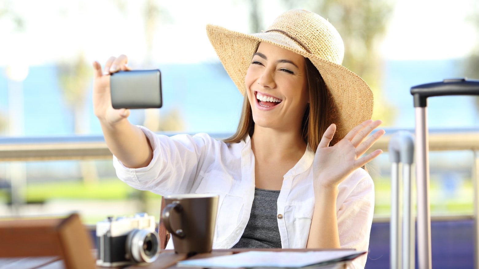 Happy tourist having a video call with a smart phone on travel destination in the beaches