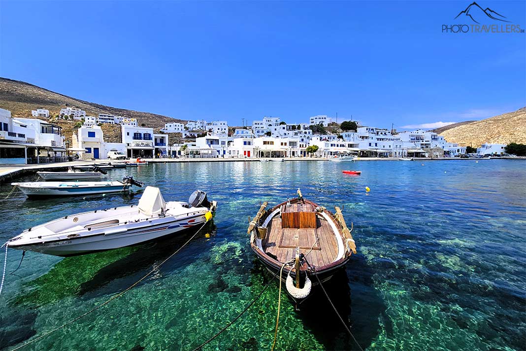 Kleine Boote ankern im türkisblauen Wasser vor den weißen Häusern im Fischerort Panormos auf Tinos
