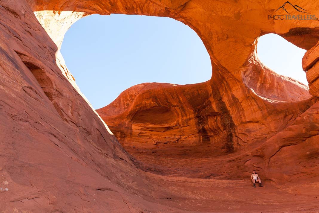 Reisebloggerin Biggi Bauer unter einer großen Doppel-Arch im Monument Valley