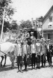 4th of July 1889 ph 1013-1 Horse-drawn carriage with people in historic clothing outside a house, vintage photo.