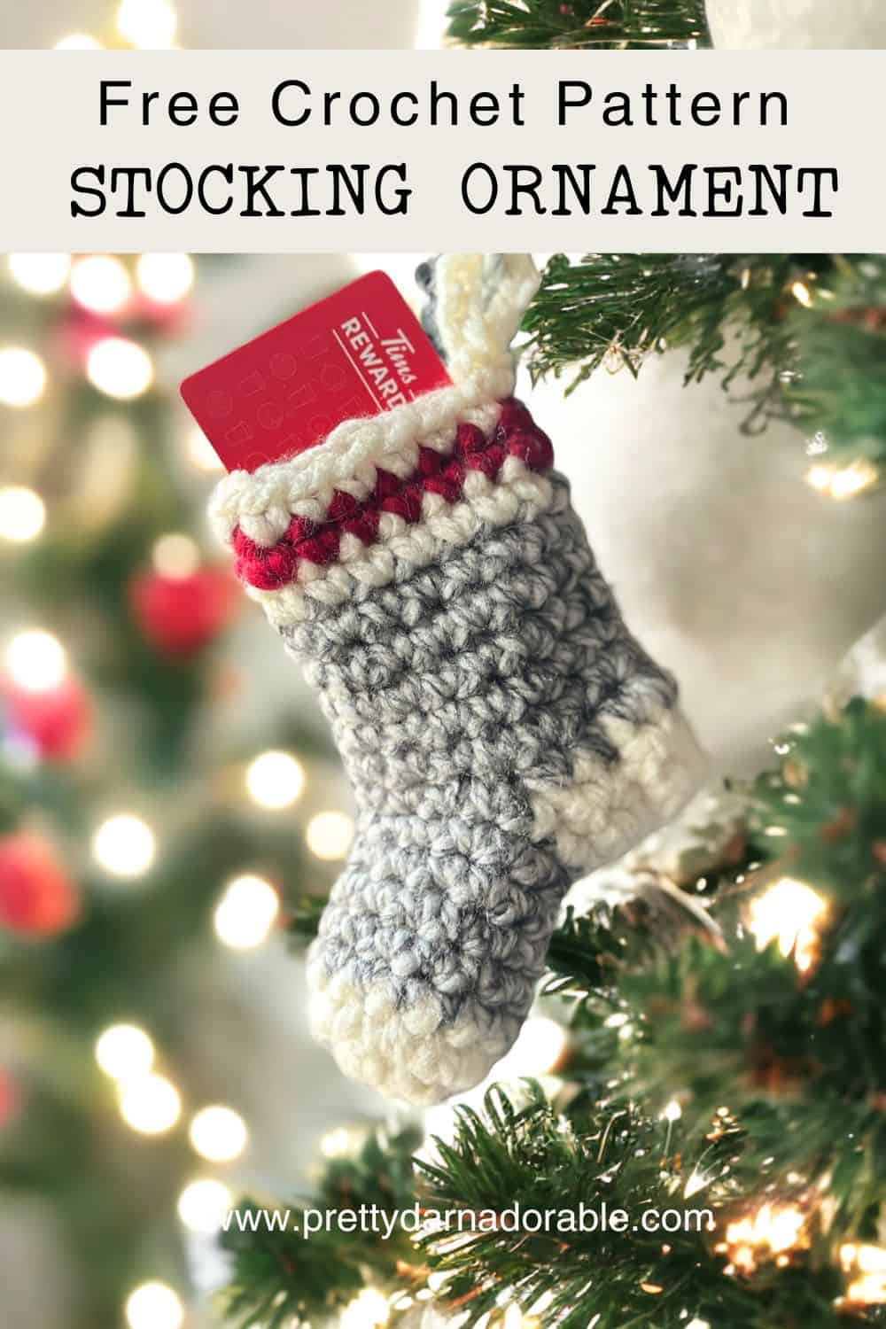 crochet christmas stocking hanging from a tree with gift card in it.