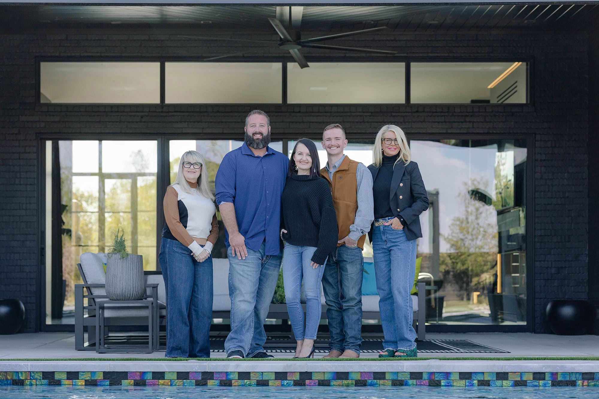 Team of professionals standing in front of a modern outdoor living space with Oklahoma City landscaping.