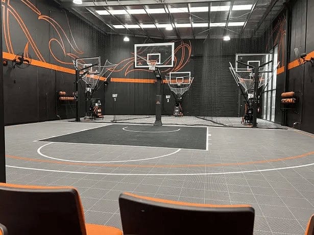 Indoor basketball court with multiple hoops and seating at No Limits Basketball facility, perfect for training and recreational play.