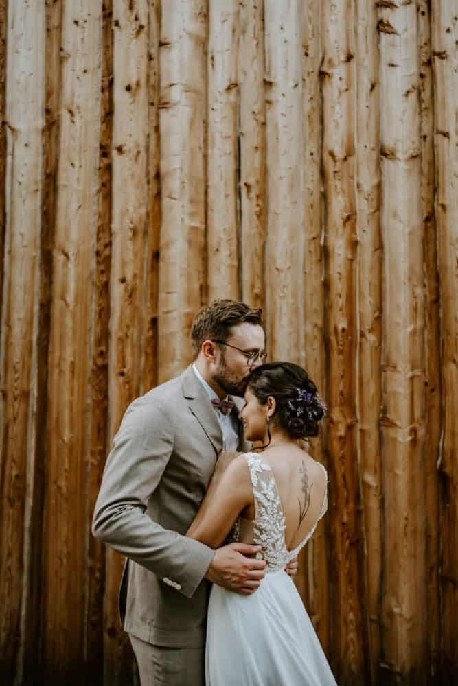 Inniger Moment vor Holzwand – Brautpaar bei Hochzeit an der Holsteins Mühle, NRW