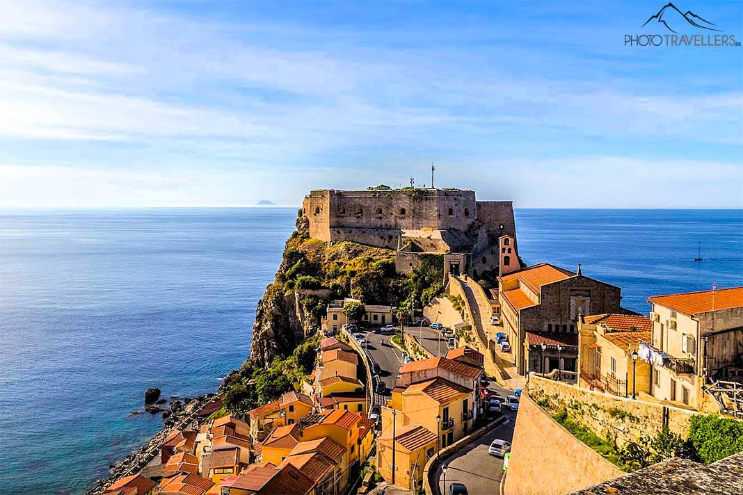 Die Burg von Scilla auf einem Felsen über dem Meer mit wenigen alten Häusern im Vordergrund