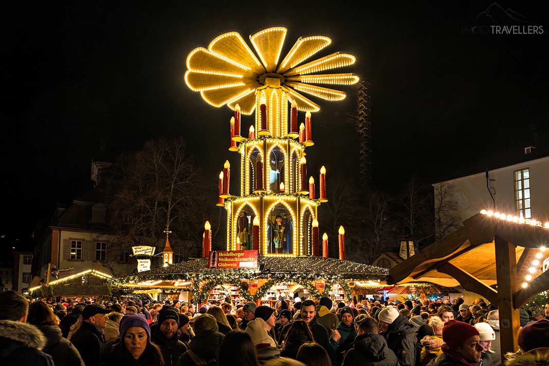 Besucher vor der beleuchteten Weihnachtspyramide auf dem Heidelberger Weihnachtsmarkt