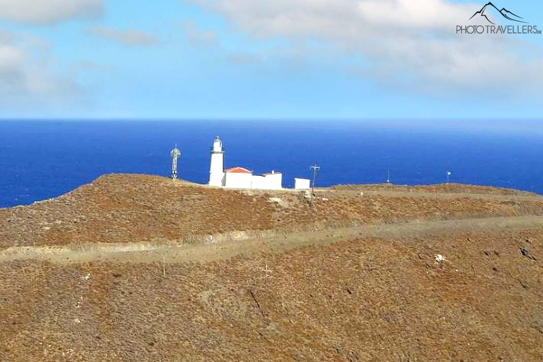 Der weiße Leuchtturm von Psara auf einem kahlen Steinhügel mit Meer im Hintergrund