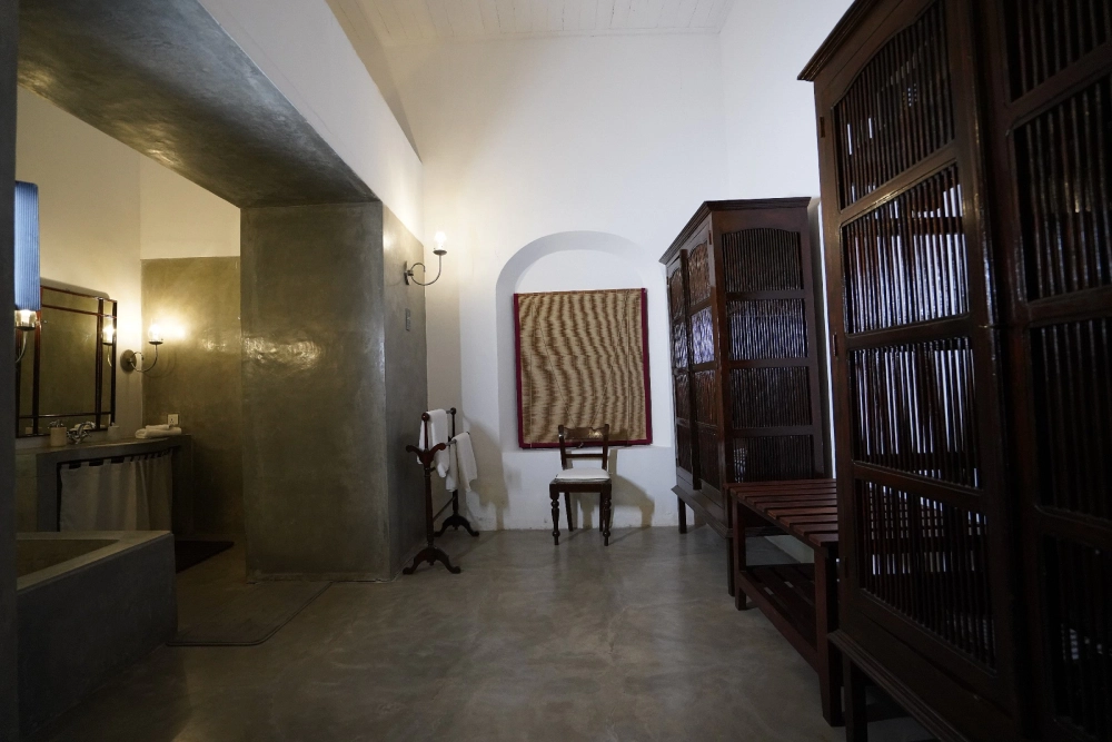 A bathroom in Adigar's Manor featuring a wooden cabinet and a mirror, set in the red spot Duke room.