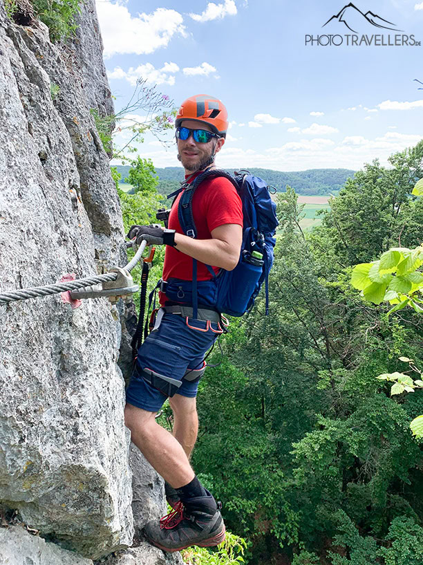 Reiseblogger Florian Westermann an einer Felswand im Klettersteig am Oberlandsteig im Altmühltal
