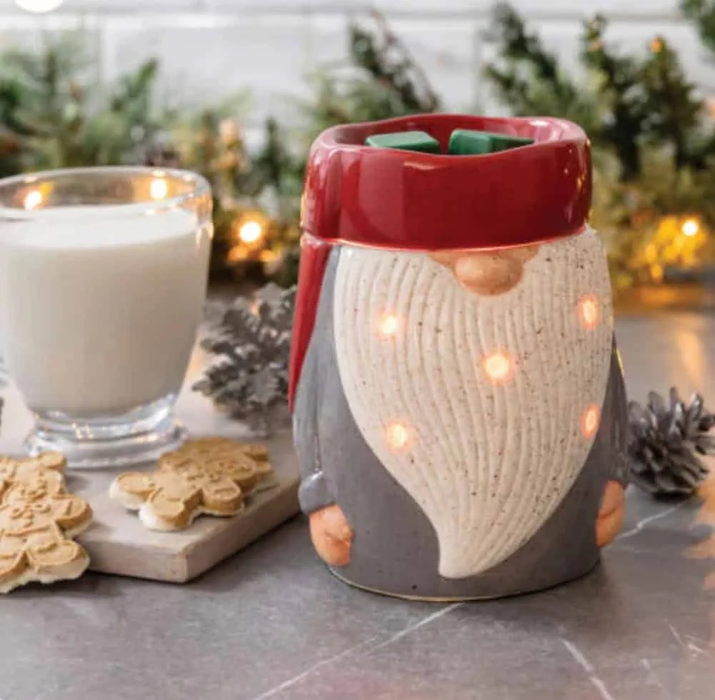 Christmas Gmones in Lights Classic T-Shirt 10 The Gnome Wax Warmer with glowing lights sits on a counter beside a glass of milk, pinecones, decorated gingerbread cookies, and festive greenery in the background.