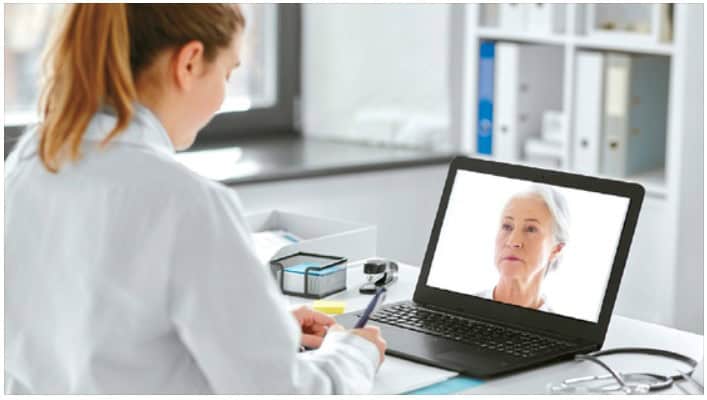 Elderly Korean woman on a video call, discussing Medicare options on a laptop.
