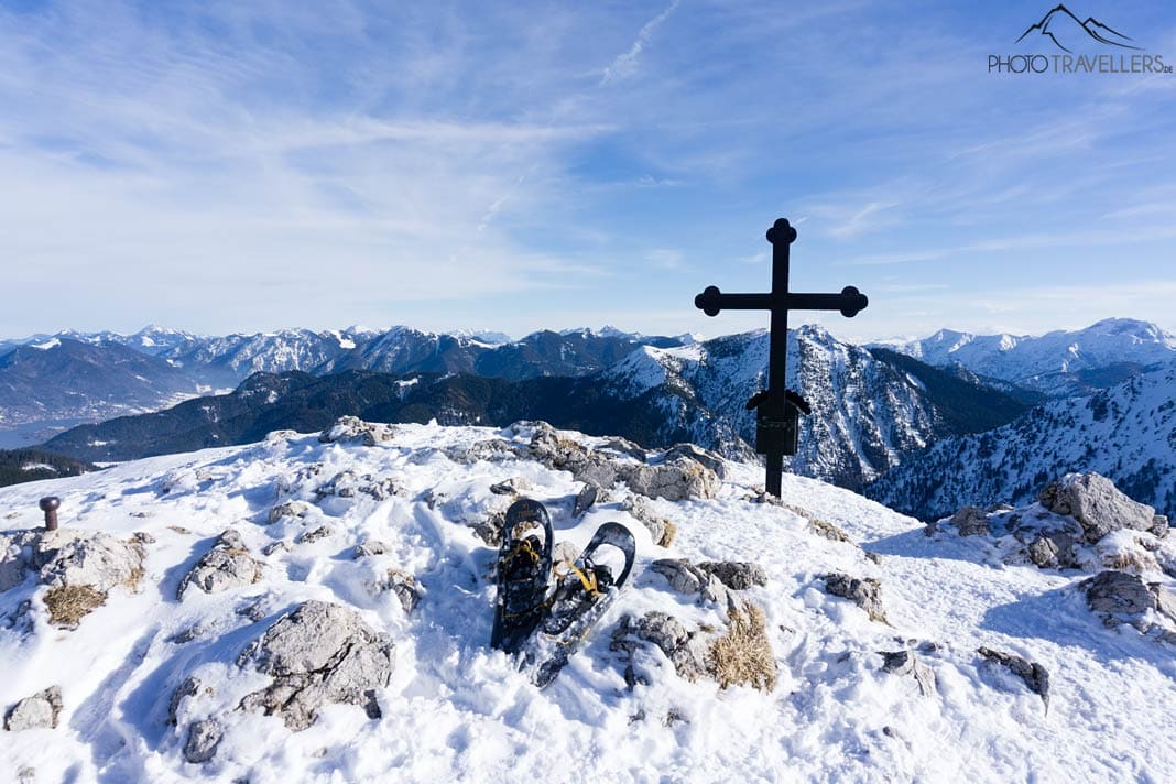 Schneeschuhe vor dem Gipfelkreuz am Fockenstein im Winter